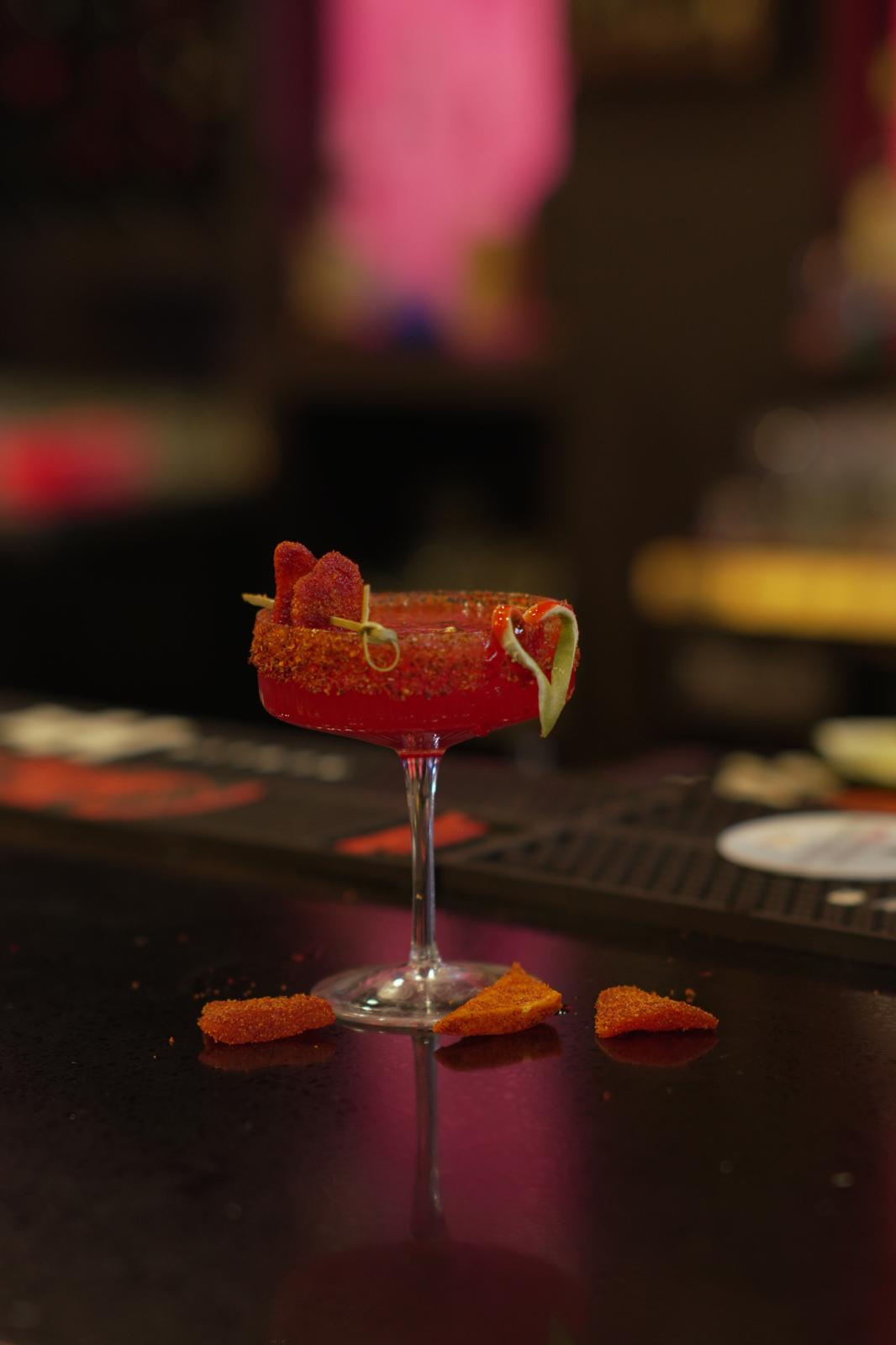 Titaura Lali red cocktail with spiced rim in a coupe glass